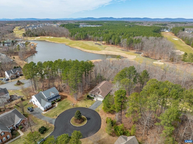 drone / aerial view featuring a wooded view and a water and mountain view