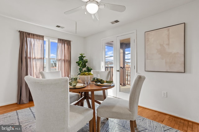 dining room featuring visible vents, baseboards, wood finished floors, and a ceiling fan