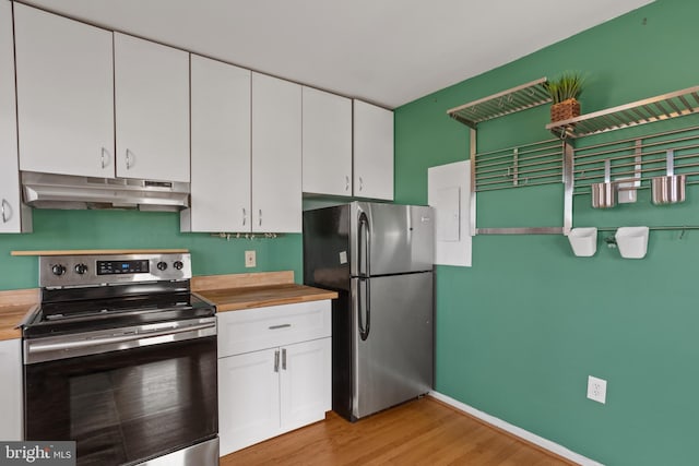 kitchen featuring butcher block countertops, white cabinets, appliances with stainless steel finishes, under cabinet range hood, and light wood-type flooring