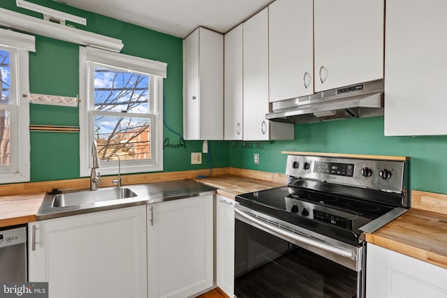 kitchen with under cabinet range hood, a sink, white cabinetry, stainless steel appliances, and wooden counters