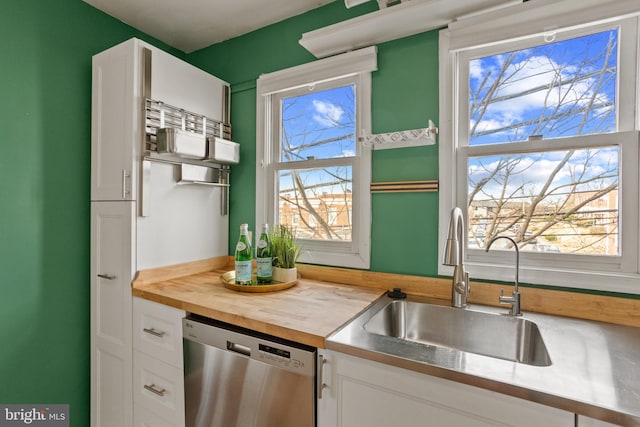 kitchen featuring a sink, butcher block countertops, dishwasher, and a healthy amount of sunlight