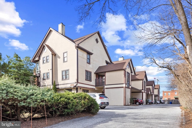 view of property exterior with stucco siding and a chimney