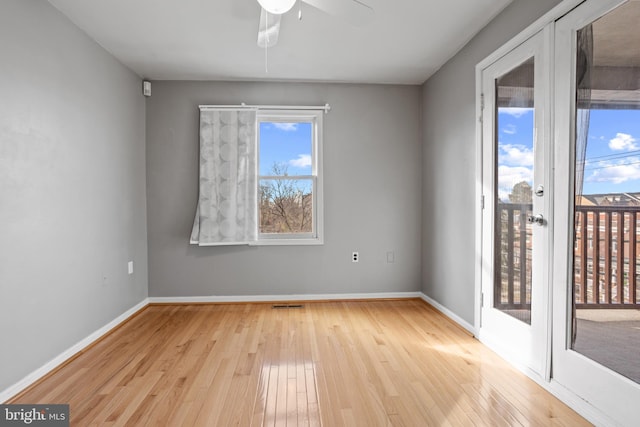 empty room with a ceiling fan, visible vents, baseboards, and light wood finished floors