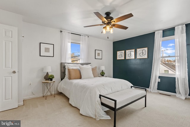 bedroom with baseboards, light colored carpet, and a ceiling fan