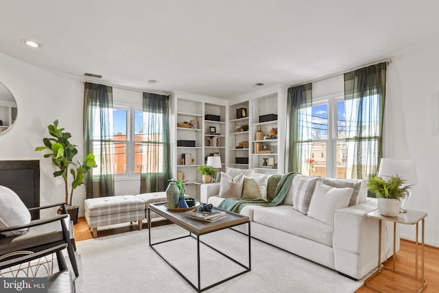 living room featuring recessed lighting, plenty of natural light, and wood finished floors