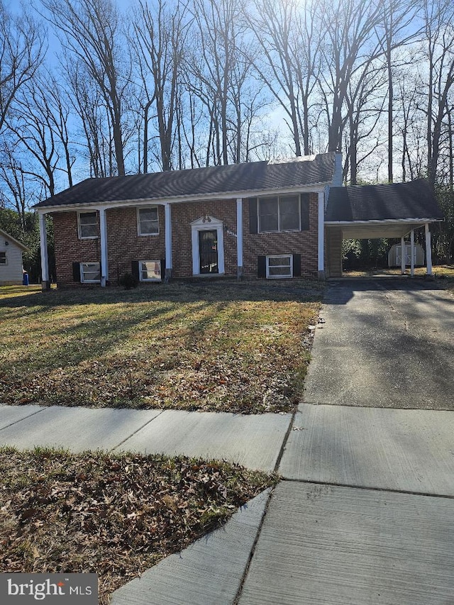 view of front of property featuring a carport, brick siding, a front lawn, and driveway