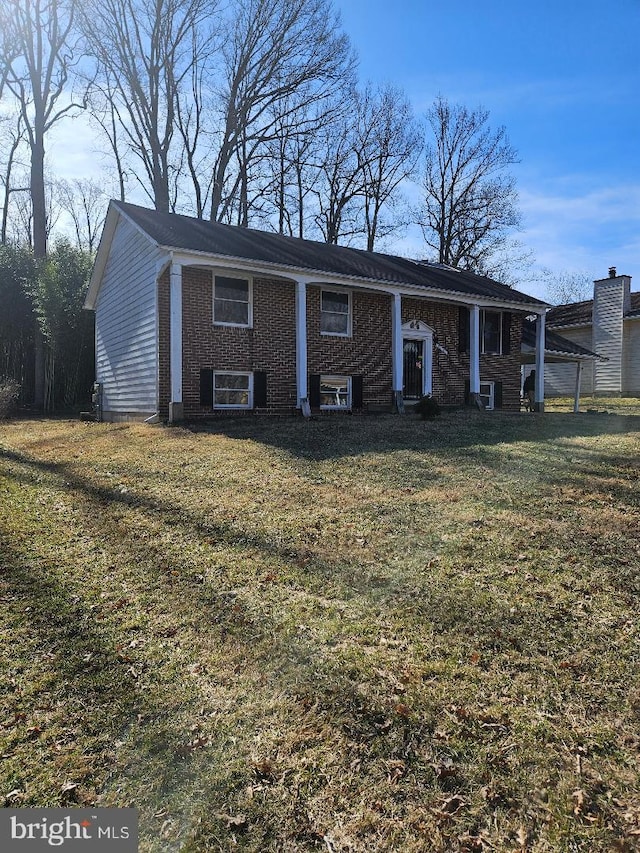 view of front of property with cooling unit, brick siding, and a front yard