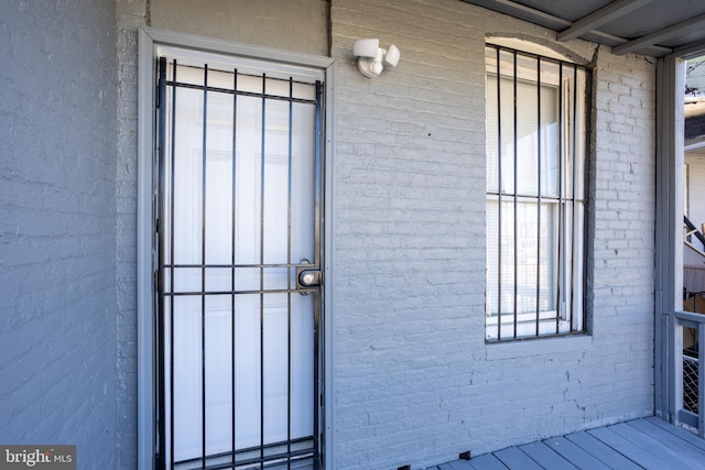 view of exterior entry featuring brick siding