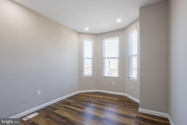 spare room with recessed lighting, baseboards, visible vents, and dark wood-style flooring