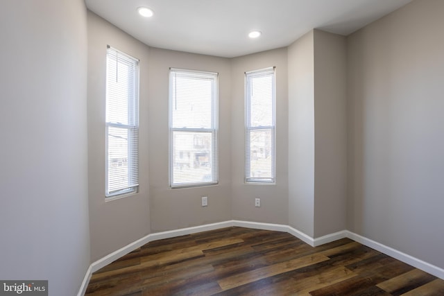 empty room featuring recessed lighting, dark wood-type flooring, and baseboards