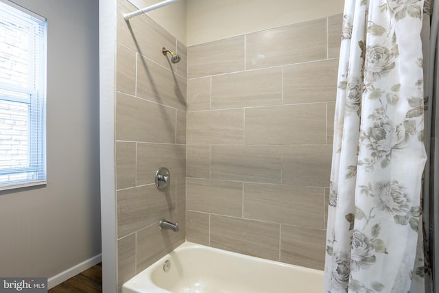 bathroom featuring baseboards and shower / bath combo with shower curtain