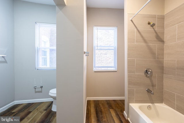 full bathroom featuring a wealth of natural light, toilet, and wood finished floors