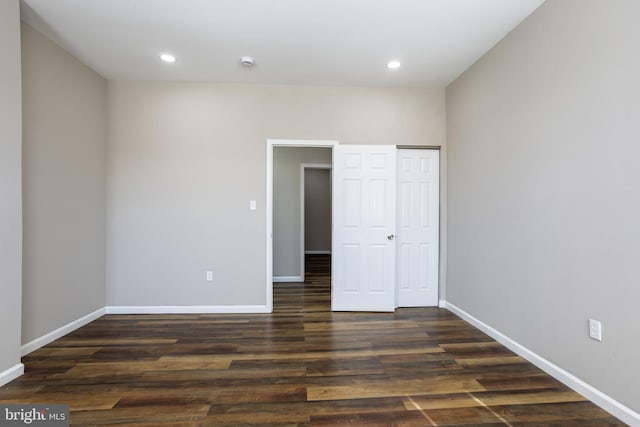 unfurnished bedroom featuring dark wood finished floors, recessed lighting, baseboards, and a closet