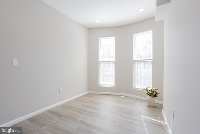 spare room with recessed lighting, light wood-type flooring, and baseboards