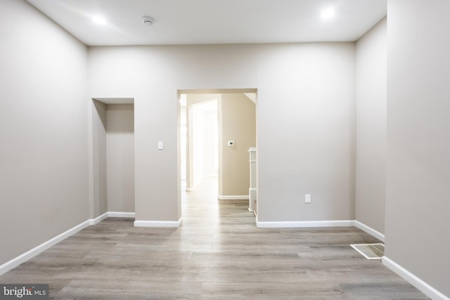 empty room with visible vents, wood finished floors, and baseboards