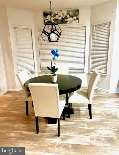 dining room with baseboards and light wood finished floors