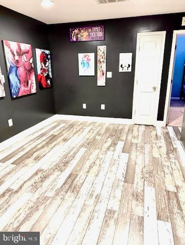 spare room featuring visible vents and wood finished floors