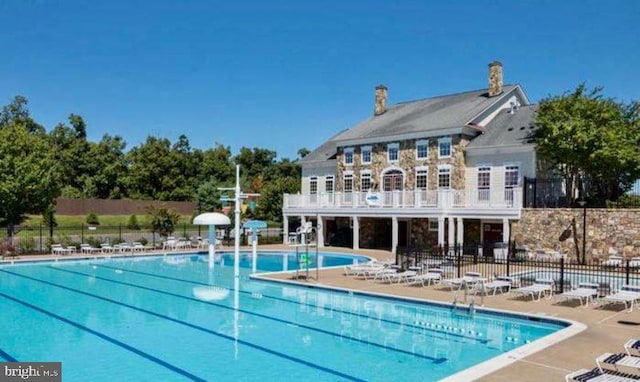 community pool featuring a patio area and fence