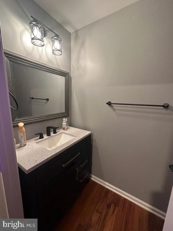 bathroom featuring vanity, wood finished floors, and baseboards