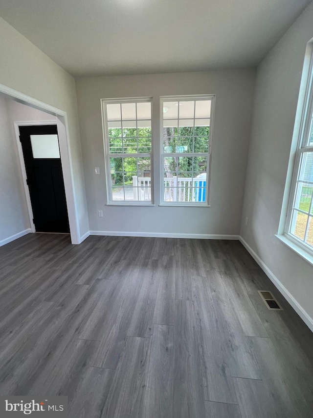 interior space with visible vents, baseboards, and dark wood-style floors