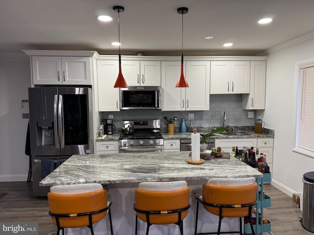 kitchen featuring ornamental molding, decorative backsplash, stainless steel appliances, white cabinetry, and dark wood-style flooring