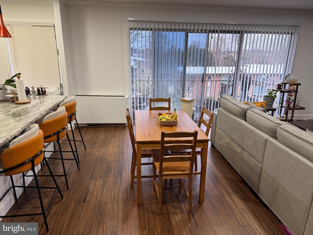 dining area with baseboards, dark wood-type flooring, and ornamental molding