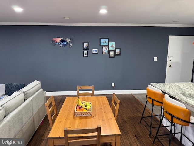 dining room with baseboards, wood finished floors, and crown molding