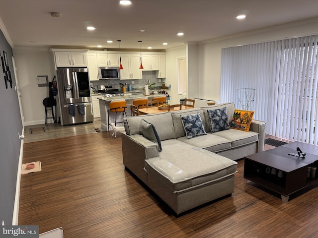 living area featuring dark wood finished floors, recessed lighting, baseboards, and ornamental molding