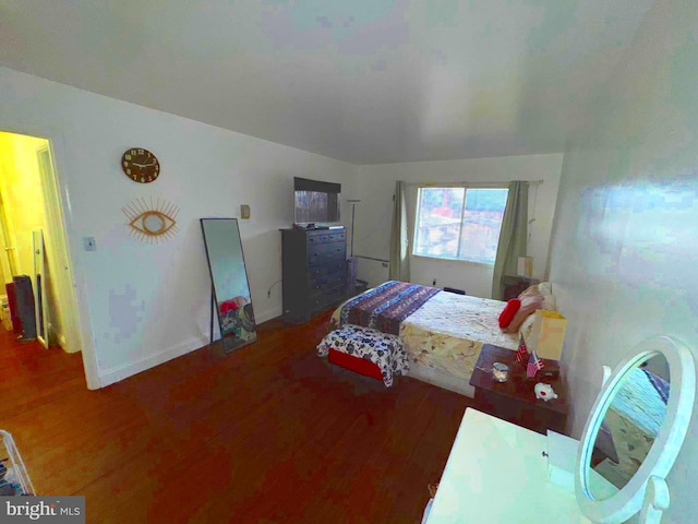 bedroom with baseboards and wood finished floors