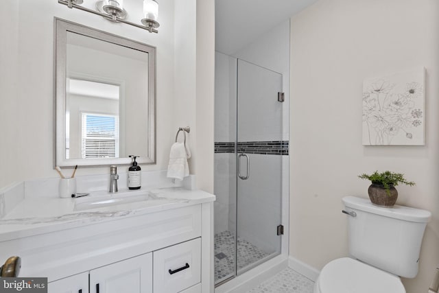 full bathroom with vanity, a shower stall, and toilet