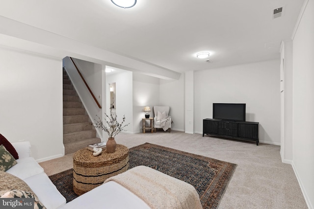 carpeted living area with stairway, baseboards, and visible vents