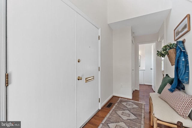 foyer entrance with visible vents, baseboards, and wood finished floors