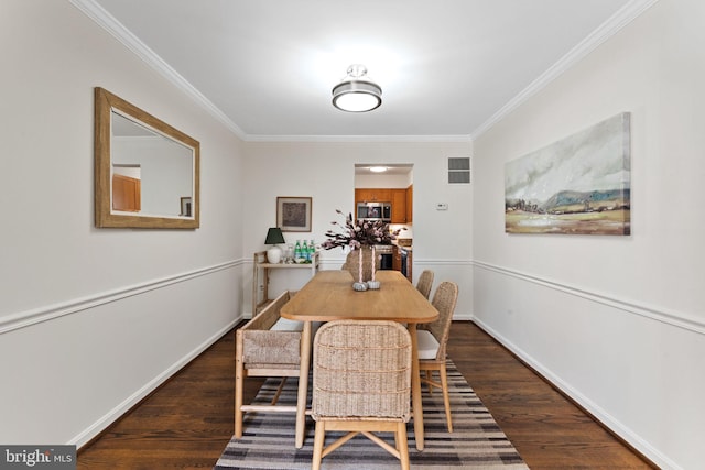 dining room with visible vents, baseboards, dark wood-style floors, and crown molding