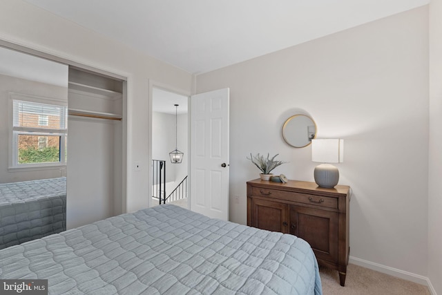 bedroom featuring a closet, light colored carpet, and baseboards