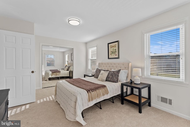 bedroom featuring visible vents, multiple windows, and carpet flooring