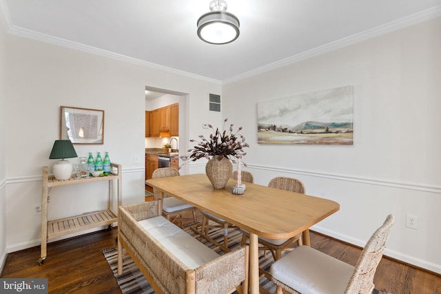 dining room with baseboards, wood finished floors, and ornamental molding