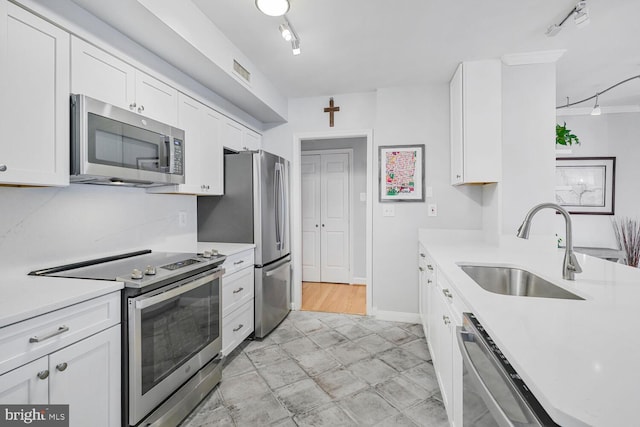 kitchen featuring visible vents, light countertops, stainless steel appliances, white cabinetry, and a sink