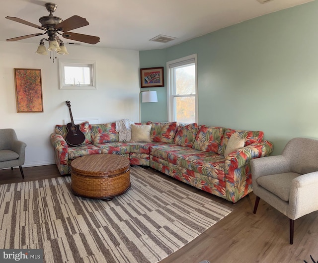 living area featuring visible vents, a healthy amount of sunlight, and wood finished floors