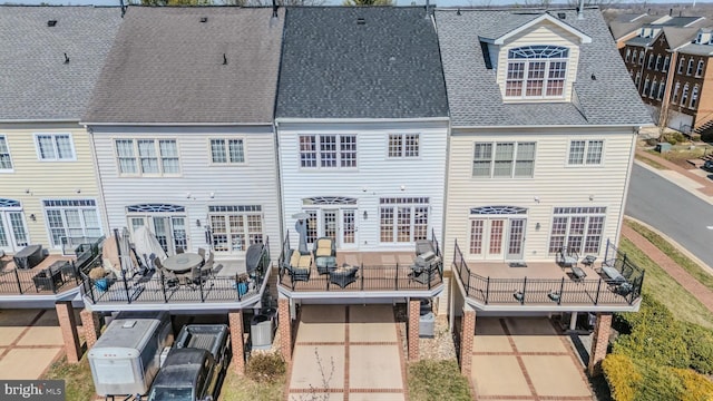 rear view of property with roof with shingles