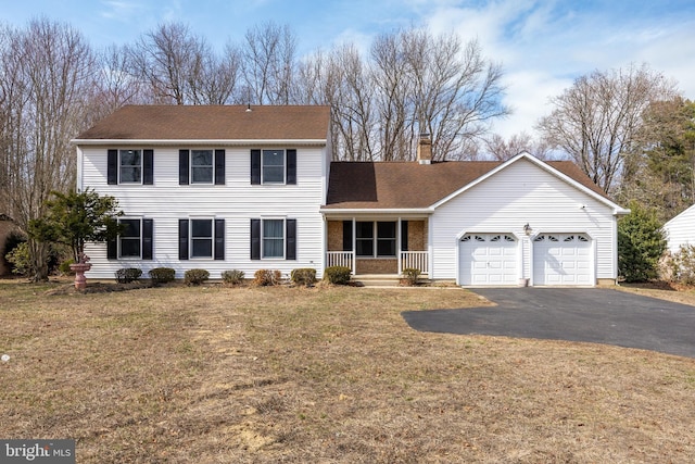 view of front of property with a garage, a front lawn, a chimney, and driveway