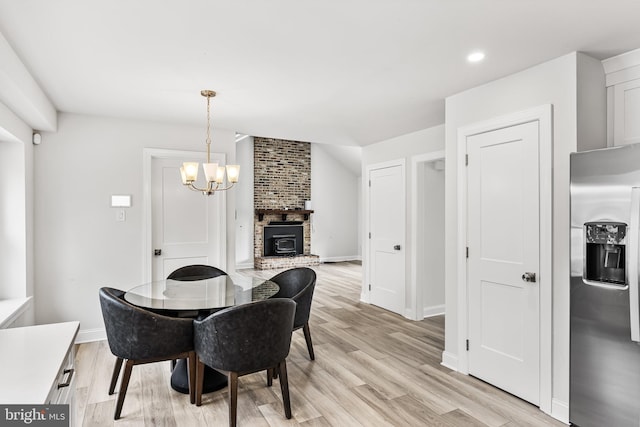 dining room featuring light wood finished floors, a notable chandelier, recessed lighting, and baseboards