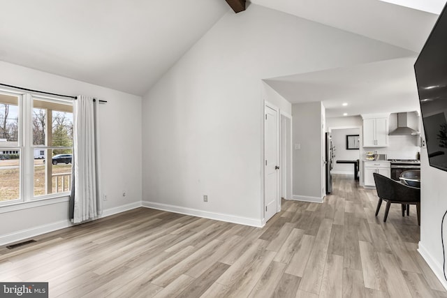 living area with beamed ceiling, visible vents, baseboards, and light wood finished floors