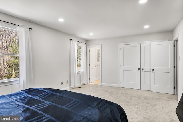 carpeted bedroom featuring recessed lighting, visible vents, baseboards, and a closet