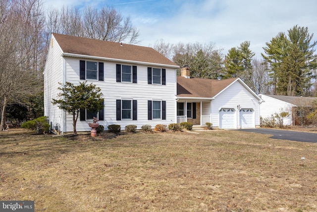 view of front of property featuring a shingled roof, aphalt driveway, a front yard, a chimney, and a garage