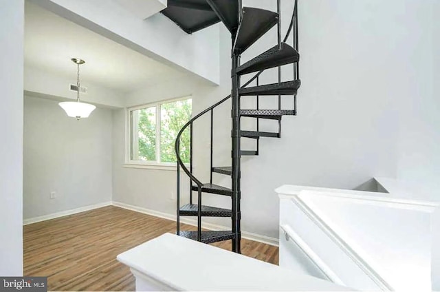 stairs featuring wood finished floors, visible vents, and baseboards