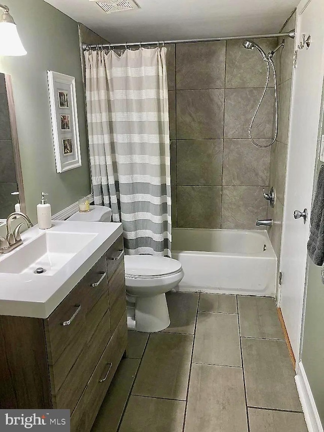 full bathroom featuring visible vents, toilet, shower / tub combo, tile patterned floors, and vanity