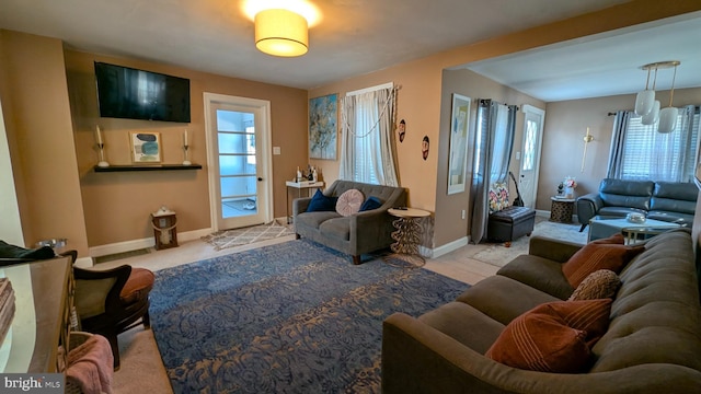 carpeted living room featuring baseboards