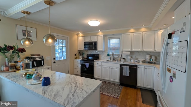 kitchen with a sink, black appliances, and white cabinetry