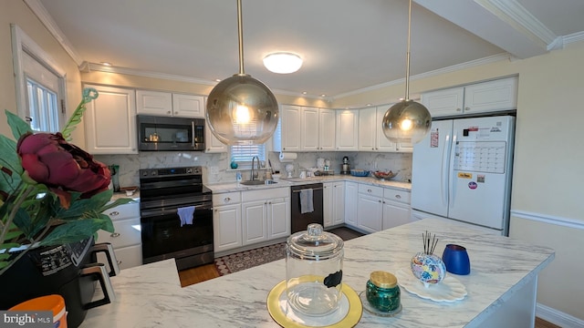 kitchen featuring light stone counters, white cabinets, stainless steel appliances, and a sink