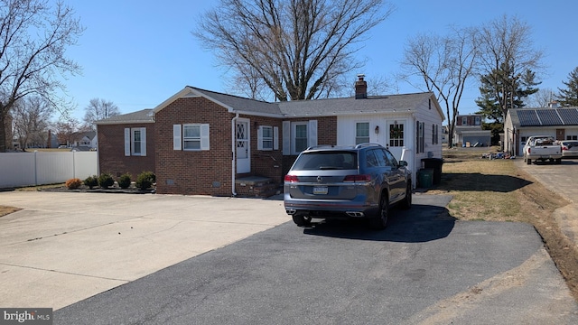 ranch-style home with crawl space, brick siding, a chimney, and fence